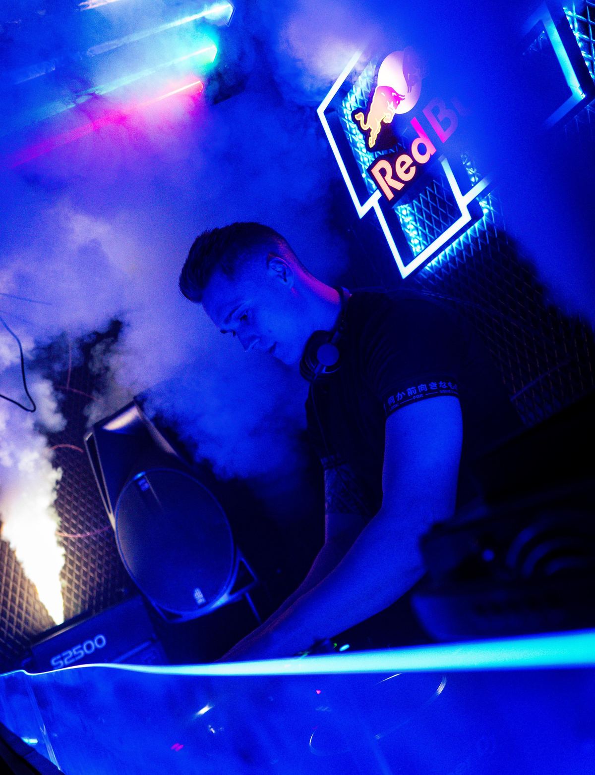 DJ Robles mezclando en la cabina de un club entre luces azules y humo