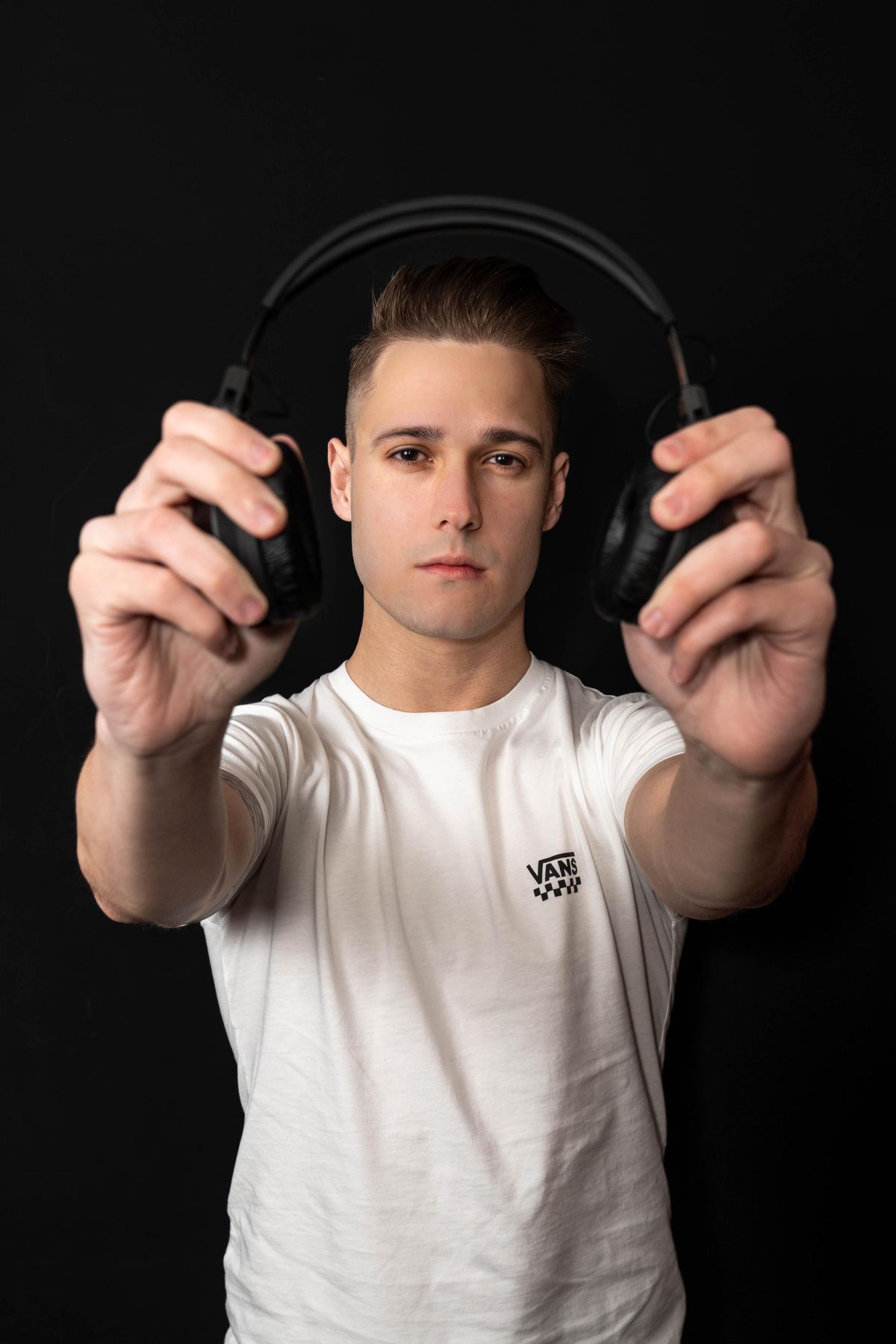 DJ Robles sosteniendo unos auriculares hacia la cámara